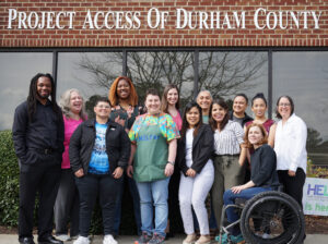 Staff photo outside in front of building with sign reading Project Access of Durham County. 