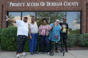 5 Client Advisory Committee members standing in front of Project Access of Durham County office. 